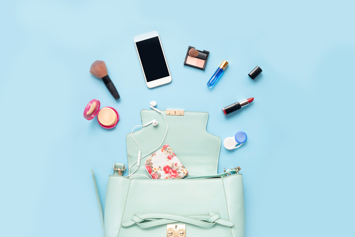 Topview of Fashionable female accessories watch glasses lipstick perfume and blue bag. Overhead of essentials for any girl, on blue background